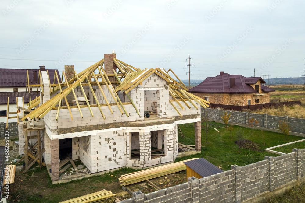 Aerial view of a private house with aerated concrete brick walls and wooden frame for future roof. Aerial view of a private house with aerated concrete brick walls and wooden frame for future roof.