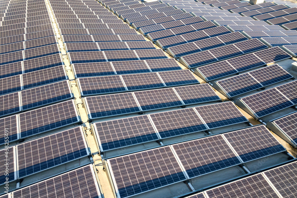 Aerial view of many photo voltaic solar panels mounted of industrial building roof. Aerial view of many photo voltaic solar panels mounted of industrial building roof.