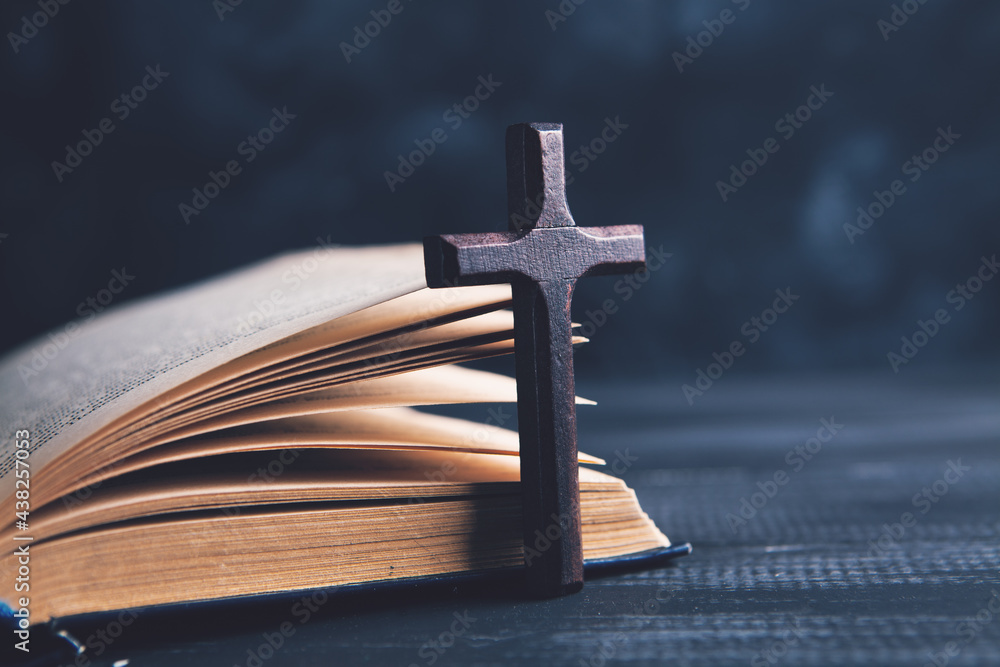 an open book and a cross on the table