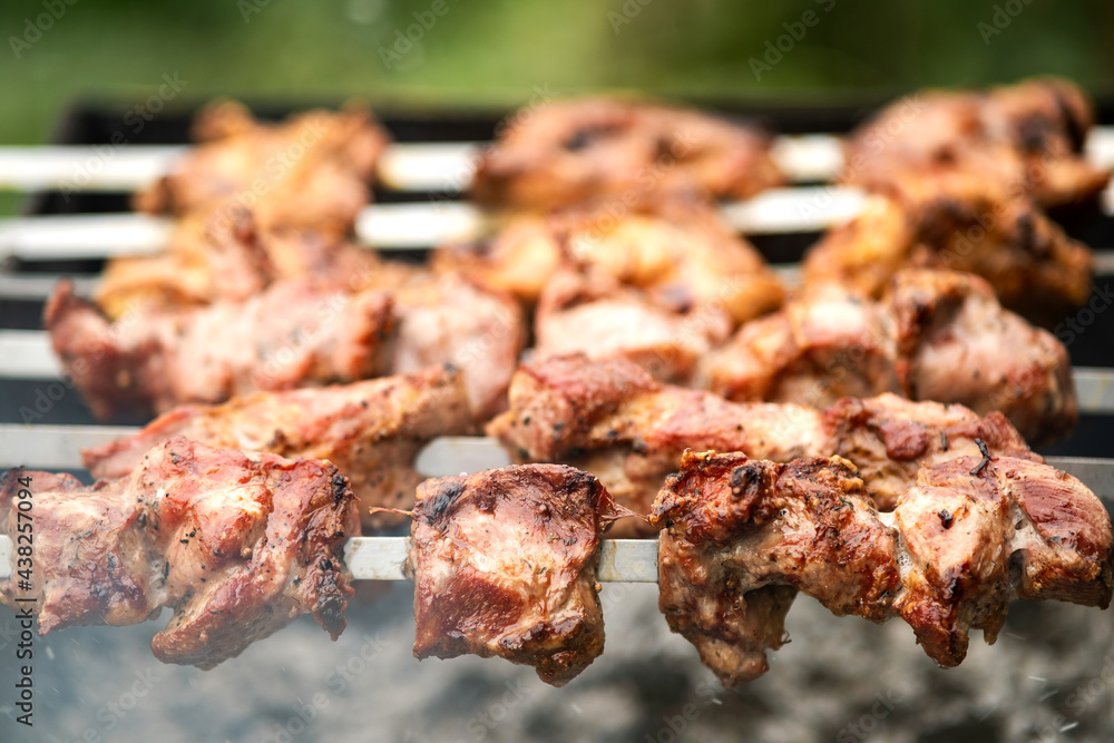 Shashlik or shish kebab preparing on barbecue grill over hot charcoal. Grilled pieces of pork meat on metal skewers. Shashlik or shish kebab preparing on barbecue grill over hot charcoal. Grilled pieces of pork meat on metal skewers.