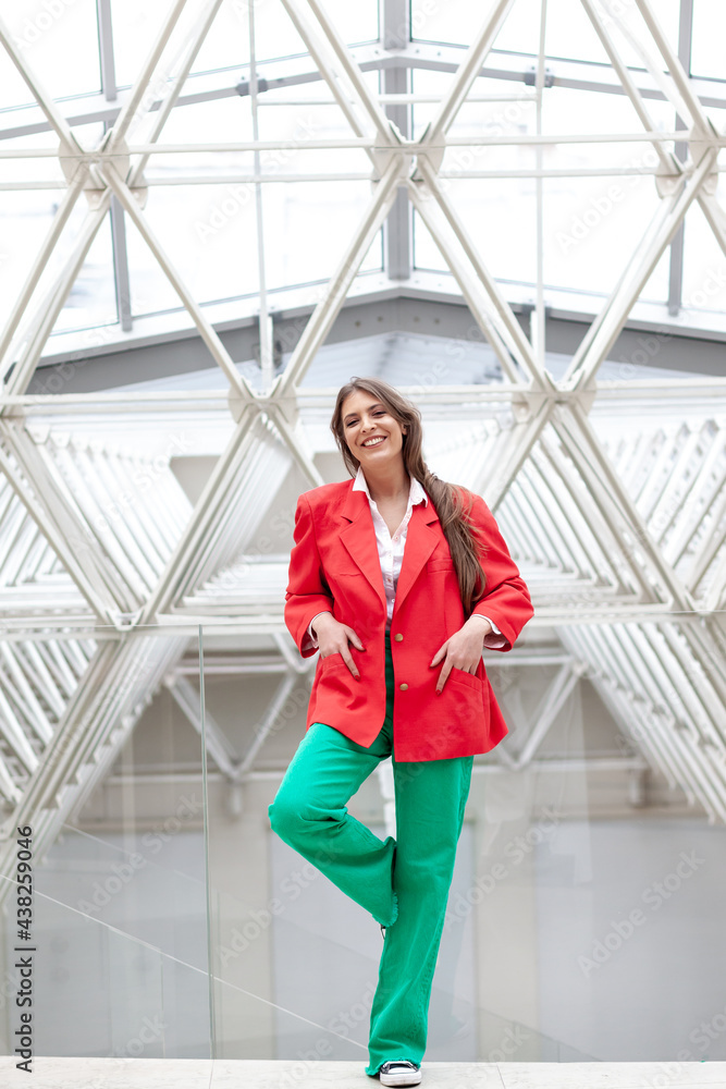 young woman wearing red jacket and green trousers