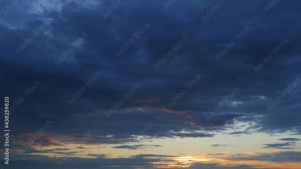 Beautiful dramatic sunset and clouds in the dark blue skies and ornamental. The sun is setting. 4K