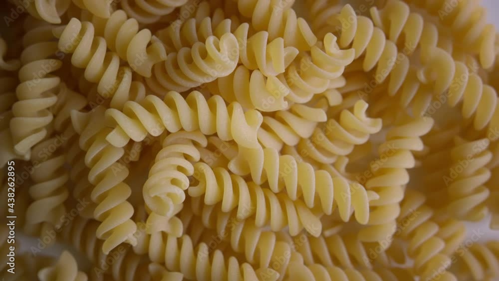 Whole grain spiral-shaped pasta rotating on white background. Macro shot Whole grain spiral-shaped pasta rotating on white background. Macro shot