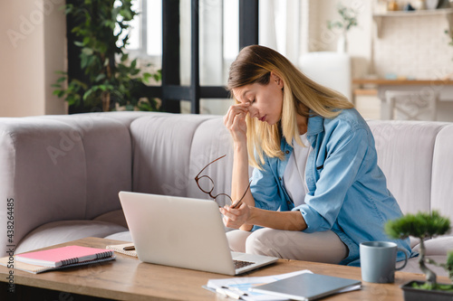 Tired exhausted stressed depressed young businesswoman student tutor teacher working at home, huge load on lockdown and remote work. Freelance job.