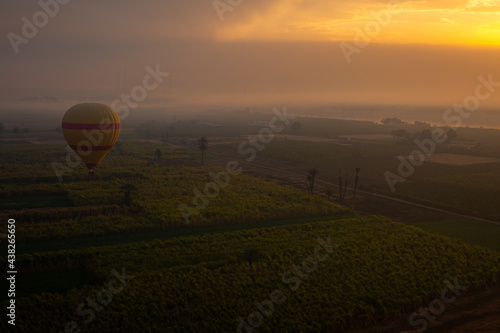 Sunrise hot air balloon flight in Luxor, Egypt. The Nile is covered in the thick morning fog.