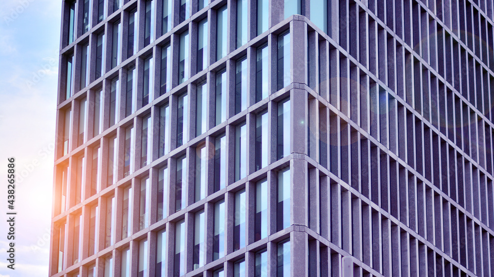 Abstract image of looking up at modern glass and concrete building. Architectural exterior detail of office building. Industrial art and detail. Sunrise.