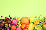 Many different delicious exotic fruits on green background, flat lay. Space for text