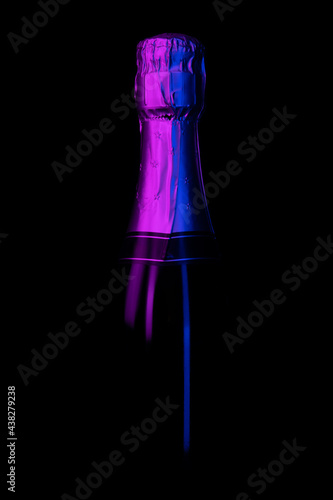 Bottle of sparkling champagne lit with neon light