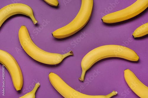 Ripe yellow bananas on purple background, flat lay