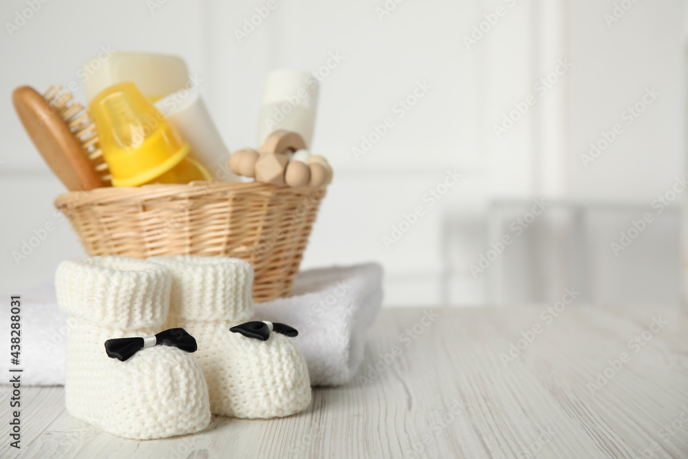 Baby booties and accessories on white wooden table indoors. Space for text Baby booties and accessories on white wooden table indoors. Space for text