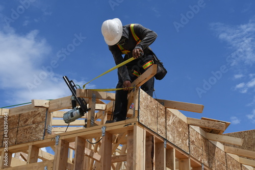 Construction worker on beams framing the house