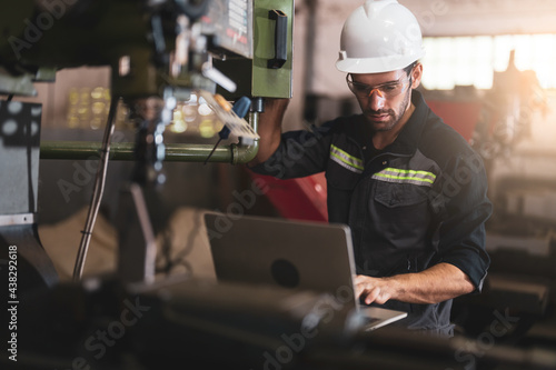 Mechanical engineer using the laptop computer and working for maintenance or repairing the machine in factory.