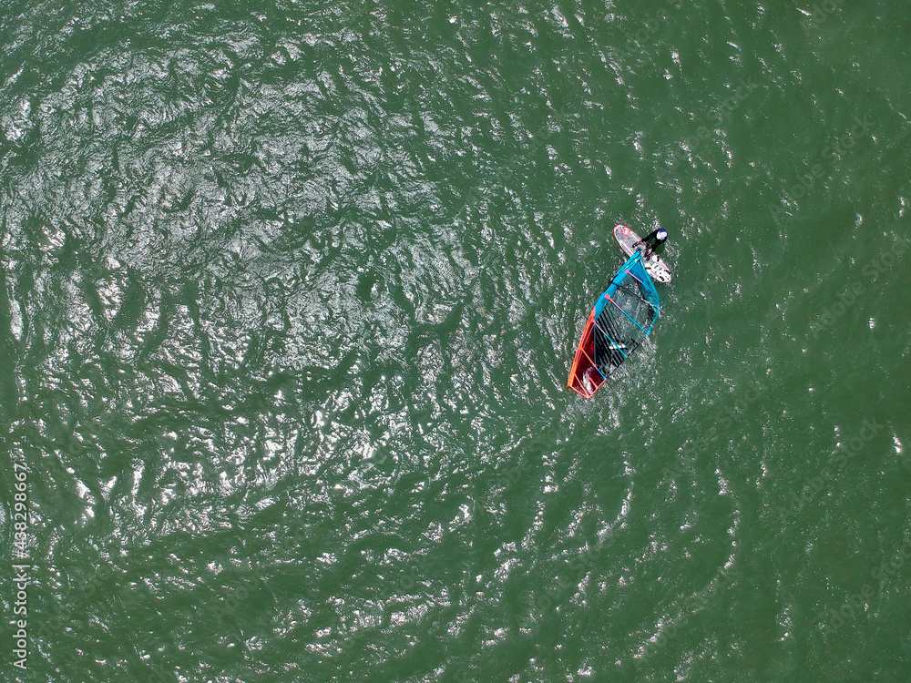 ドローンで空撮した夏の海でウィンドサーフィンをやっている人の姿