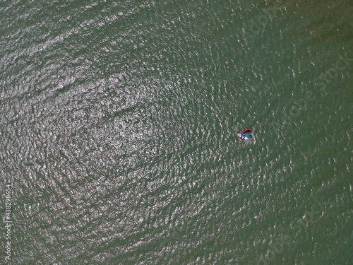 ドローンで空撮した夏の海でウィンドサーフィンをやっている人の姿