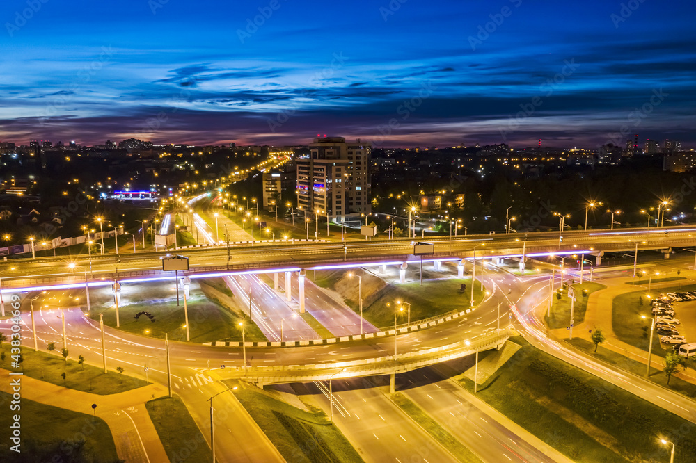 Fototapeta premium aerial drone photo of urban multilevel ring junction road in twilight time. long exposure.