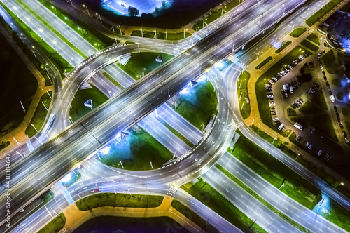 aerial top view from drone of modern multilevel road intersection and roundabout at night