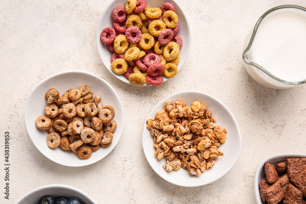 Bowls with different cereals and milk on light background Bowls with different cereals and milk on light background