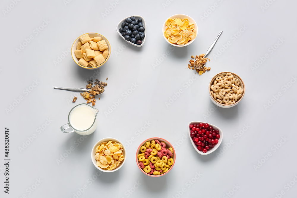 Frame made of different cereals, berries and milk on light background Frame made of different cereals, berries and milk on light background