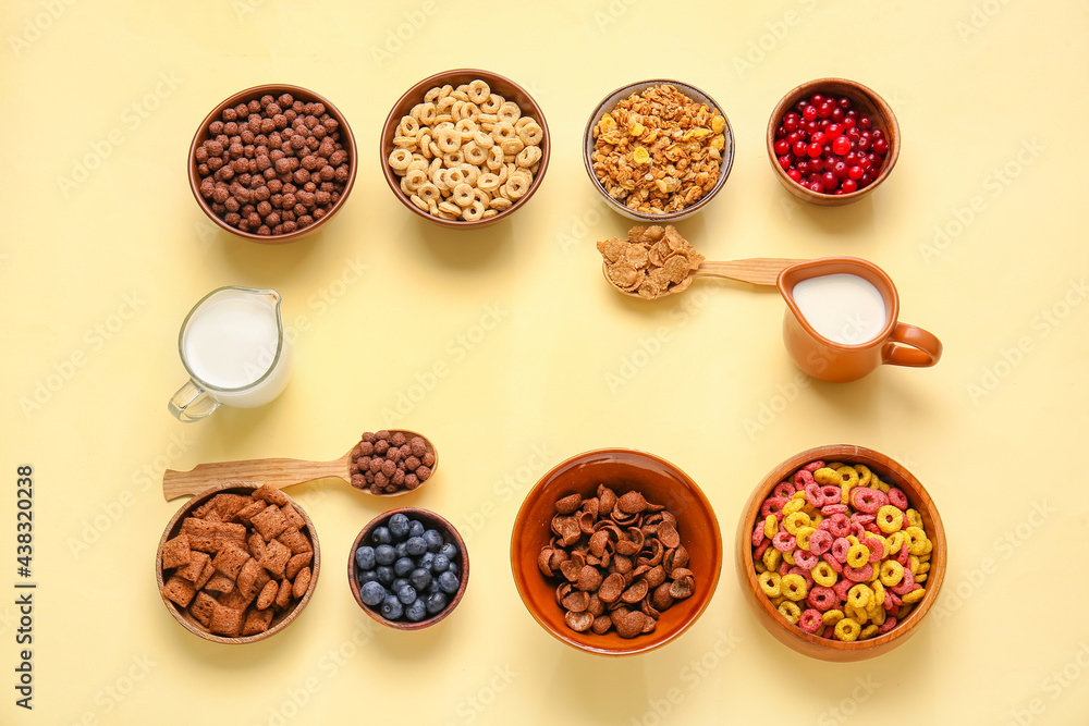 Frame made of different cereals, milk and berries on color background Frame made of different cereals, milk and berries on color background
