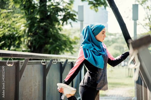 Photography Muslim woman stretching after workout at the park