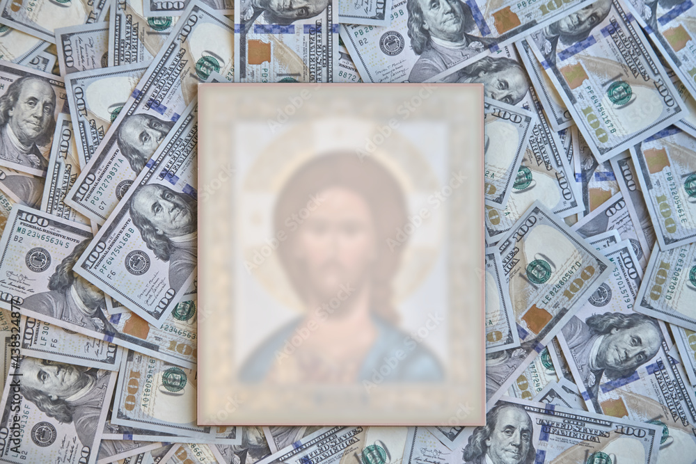 silhouette of a religious icon against a background of hundred-dollar bills