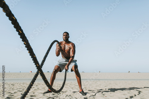 Fit man working out with battle ropes photo