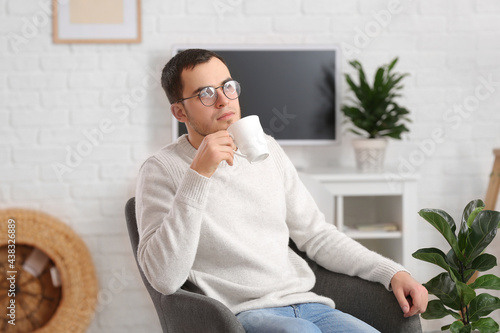Young man drinking tea at home