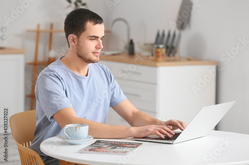 Handsome man using laptop at home