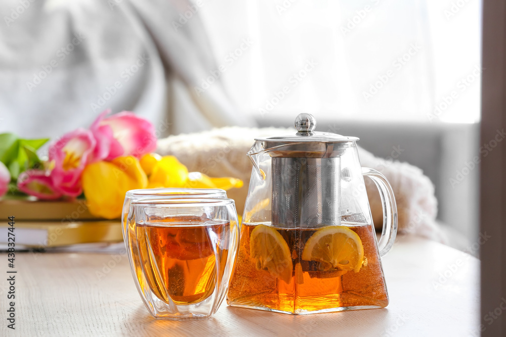 Teapot and cups of hot beverage on table in room Teapot and cups of hot beverage on table in room