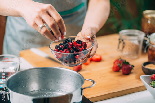 Woman Cooking Fruits and Making Homemade Jam.