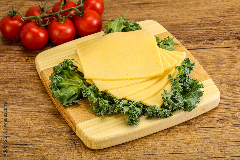 Sliced Gauda cheese over board Sliced Gauda cheese over board