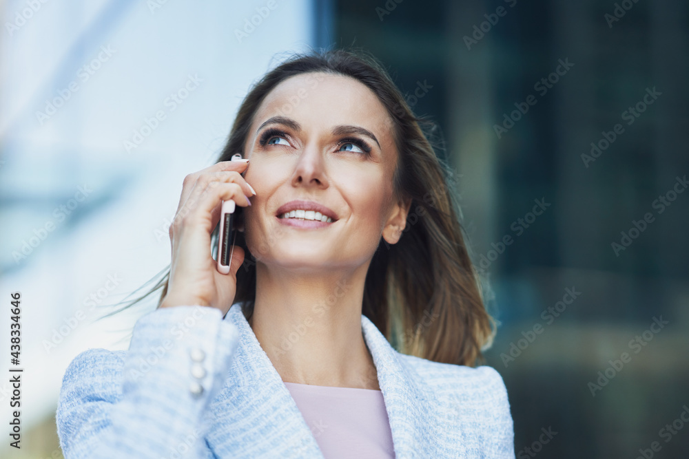 Adult attractive business woman with smartphone walking in the city Adult attractive business woman with smartphone walking in the city