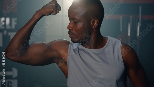 Portrait of handsome fitness black man in gym, Personal trainer show his muscular different movements and body parts, Muscles workout fitness and bodybuilding, sport healthy lifestyle concept