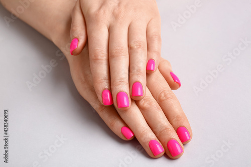 Woman with beautiful manicure on light background