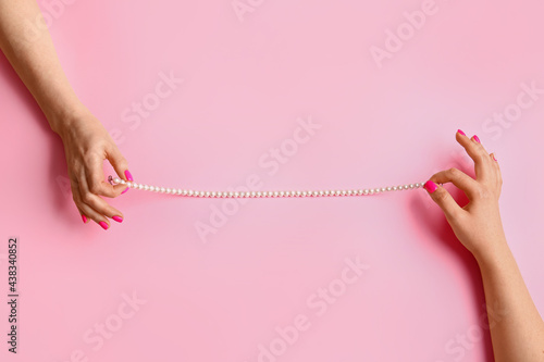 Women with beautiful manicure and necklace on color background