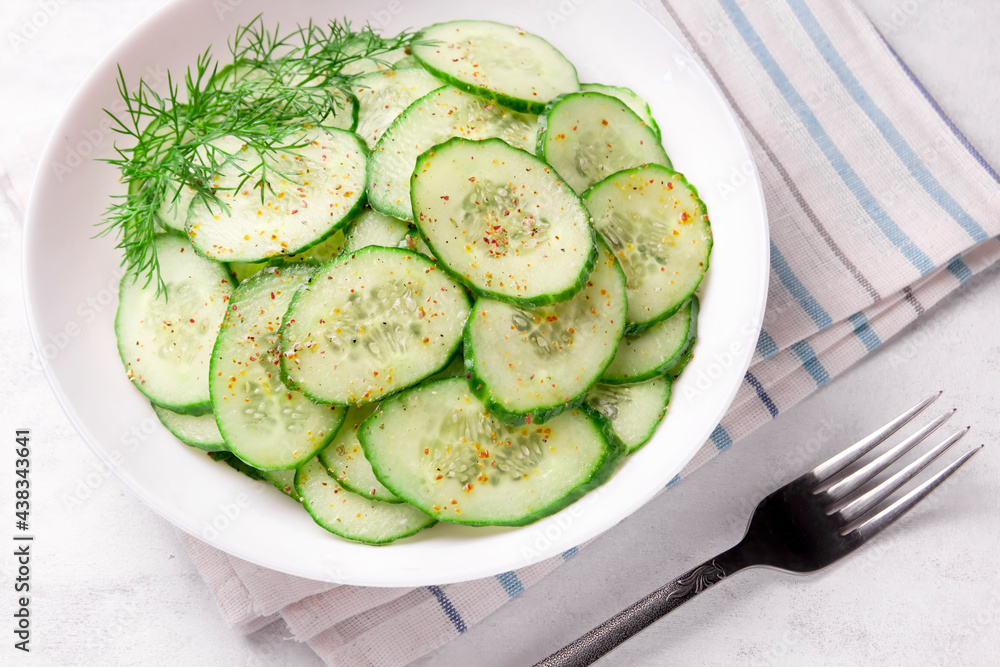 Fresh cucumber salad in bowl on white background Fresh cucumber salad in bowl on white background