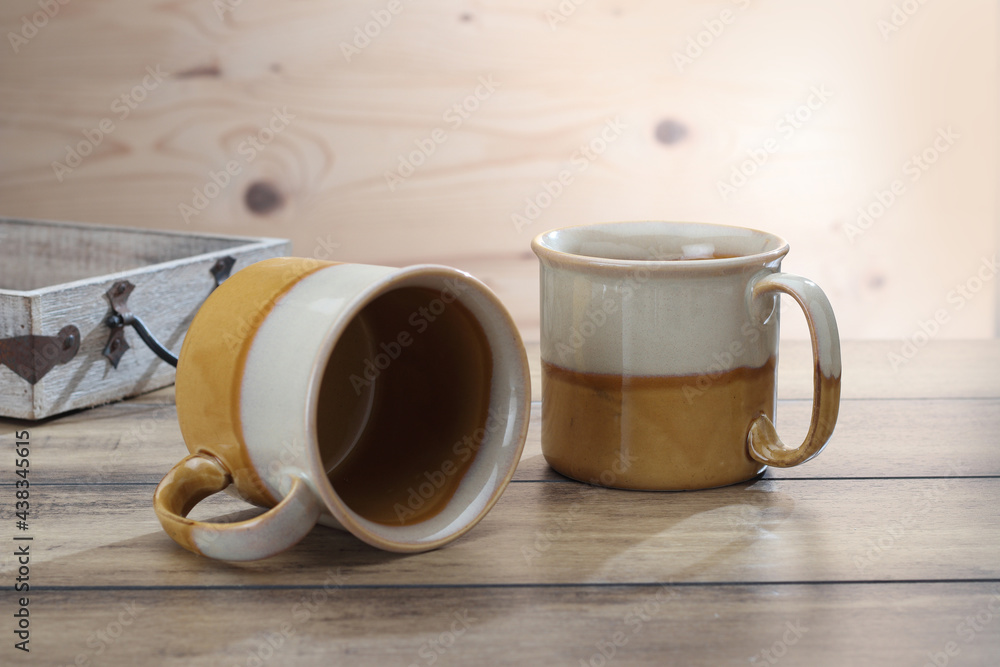 Obraz premium ceramic coffee mugs on a textured wooden base.
