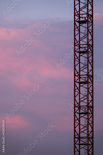 dramatic pink sky with construction crane in foreground