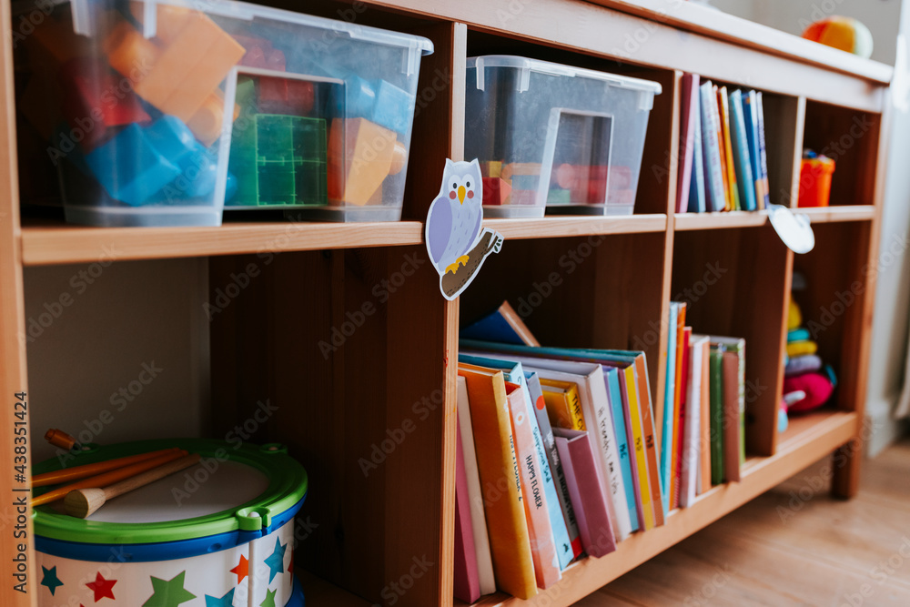 Shelves of toys and books in a nursery school - obrazy, fototapety, plakaty 