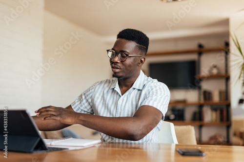 Adult African man, talking to his employees, online.