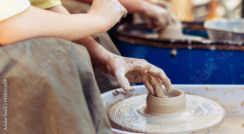 A craftsman on the street makes a clay figure in a pottery