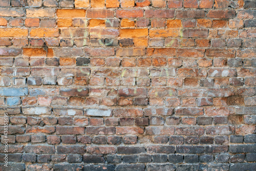Old crumbling brick wall as background close up