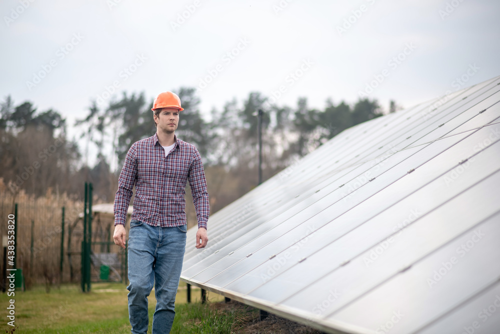 Concentrated man in helmet near engineering structure Concentrated man in helmet near engineering structure