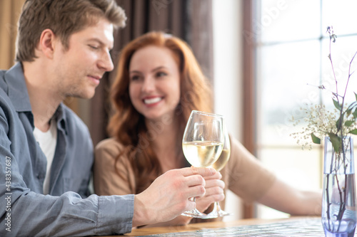 Happy couple with glasses of wine in restaurant
