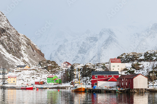 Harbor with boats in front of snow covered mountains