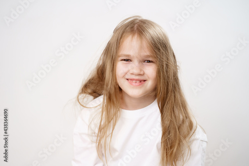 cute little girl with shaggy long hair on a white background