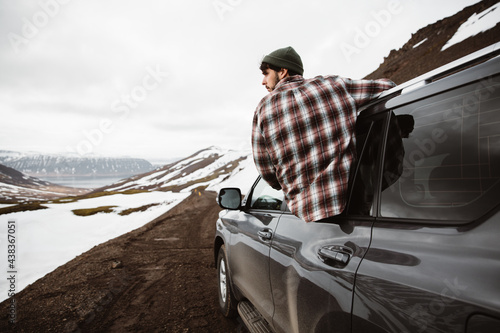 Man sticking out of car in remote land