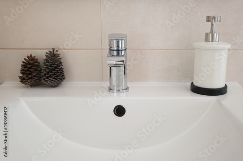 Bathroom countertop with bottle of hand gel and ornaments. Close up and front view