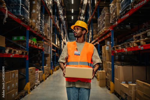 Worker carrying cardboard boxes at warehouse