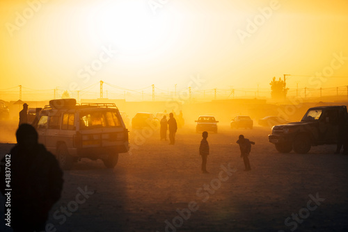 Cars and people in refugee camp